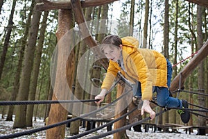 Boy climbing in adventure park. Child having fun in adventure park.