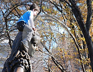 Boy Climbing on Alice in Wonderland in Central Park