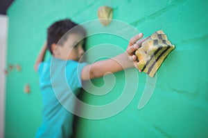 Boy climbing green wall