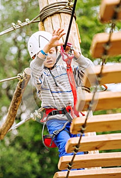 Boy climbing rope-ladder in adrenalin park