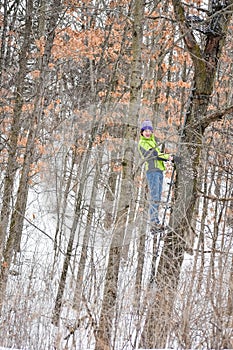 Boy Climbing up a Deer Stand in Forest