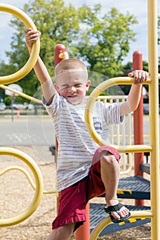 Boy Climbing Up Jungle Gym On Playscape