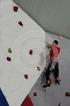 Boy on the climbing wall. The child holds on to the hooks with his hands