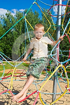 The boy climbs the ropes