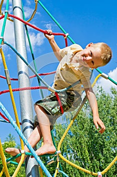 The boy climbs the ropes