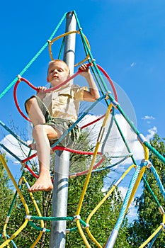 The boy climbs the ropes