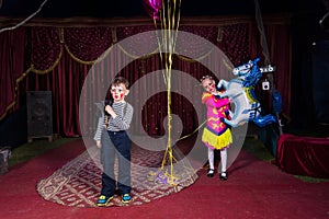 Boy Clown on Stage with Girl Holding Horse Balloon