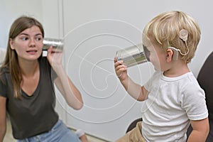 Boy with Cochlear Implants Playing Tin Can Phone photo