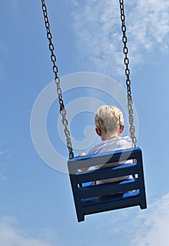 A Boy With Cochlear Implants Riding Swing in Park