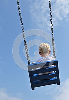 A Boy With Cochlear Implants Riding Swing in Park photo