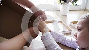 The boy collects a packing cardboard box with his hands, his mother helps him