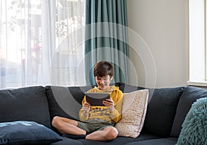 A boy connext to the friend via tablet during qaurantine