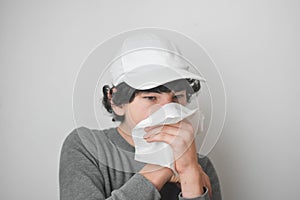 A boy coughing into a Kleenex Tissue