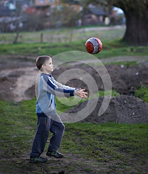 Boy in countryside plays the ball