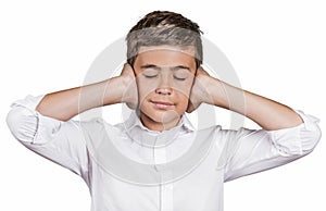 Boy covering ears with hands, doesn't want to hear loud noise, ignoring conversation