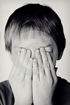 Boy Covering Eyes with Hands