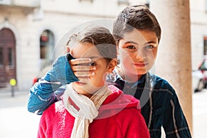 Boy covers eyes of his sister, portrait