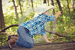 Boy Crawling on Tree Trunk Pointing