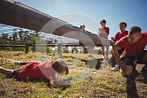 Boy crawling under the net during obstacle course training