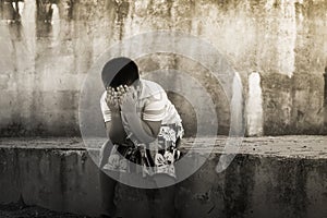 Asian boy crying alone at old wall ,vintage tone