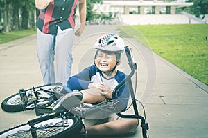 Boy crying while his father trying to help at park