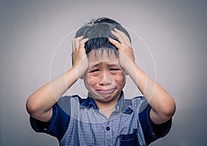 Boy crying over dark background