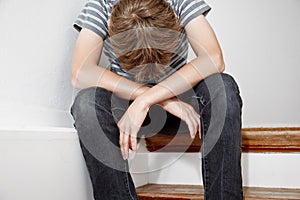 Boy crying while sitting on the stairs