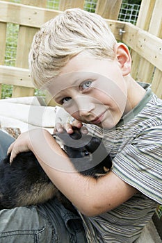 Boy cuddling up with pet rabbit