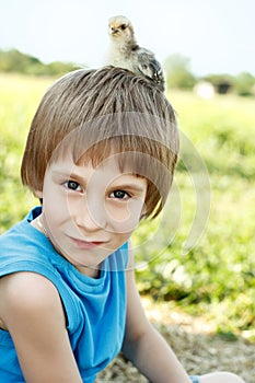 Boy cute with chiken on his head nature