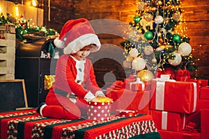 Boy cute child cheerful mood play near christmas tree. Merry and bright christmas. Lovely baby enjoy christmas