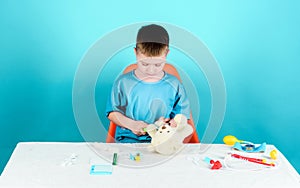 Boy cute child future doctor career. Hospital worker. Health care. Kid little doctor busy sit table with medical tools