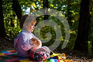 Boy cute child play with teddy bear toy forest background. Picnic with teddy bear. Hiking with toy. Little tourist