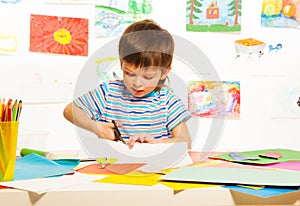 Boy cutting paper with scissors