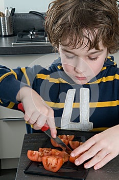 Boy cutting tomato
