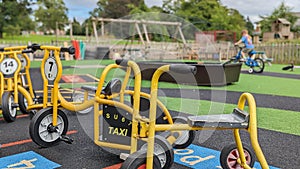 A boy cycles his bike around a school park playground