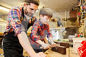 Boy and dad with calipers measure wood at workshop