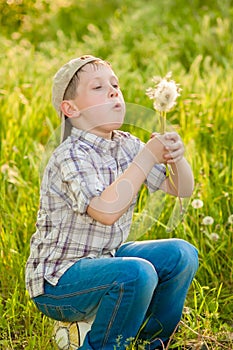 Boy with dandelions in summer