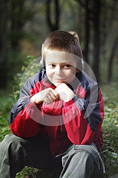Boy in dark forest listens music