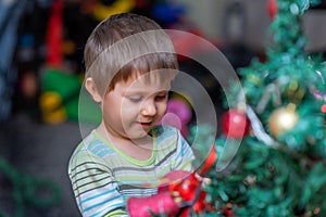 The boy decorates the Christmas tree. Children in Xmas