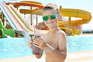 Boy with refreshing drink in water park