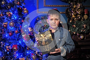 Boy in a denim shirt with a gift in hands