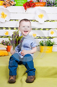 Boy in a denim suit with a bouquet of flowers in their hands