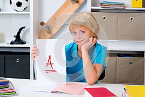 Boy on desk with good report card