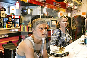 Boy in a diners studies the menu at the wall