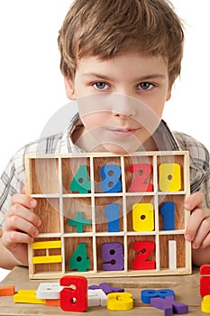 Boy displays wooden figures in form of numerals photo