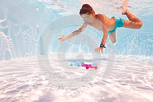 Boy dive underwater take toys in pool with googles photo