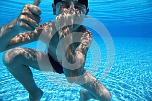 Boy dives under water in pool photo