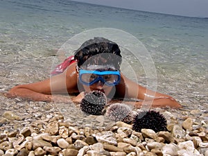 Boy, diving mask, sea urchins