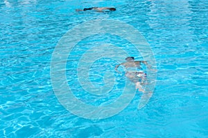 Boy in diving mask swim underwater in the swimming pool