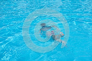 Boy in diving mask swim underwater in the swimming pool